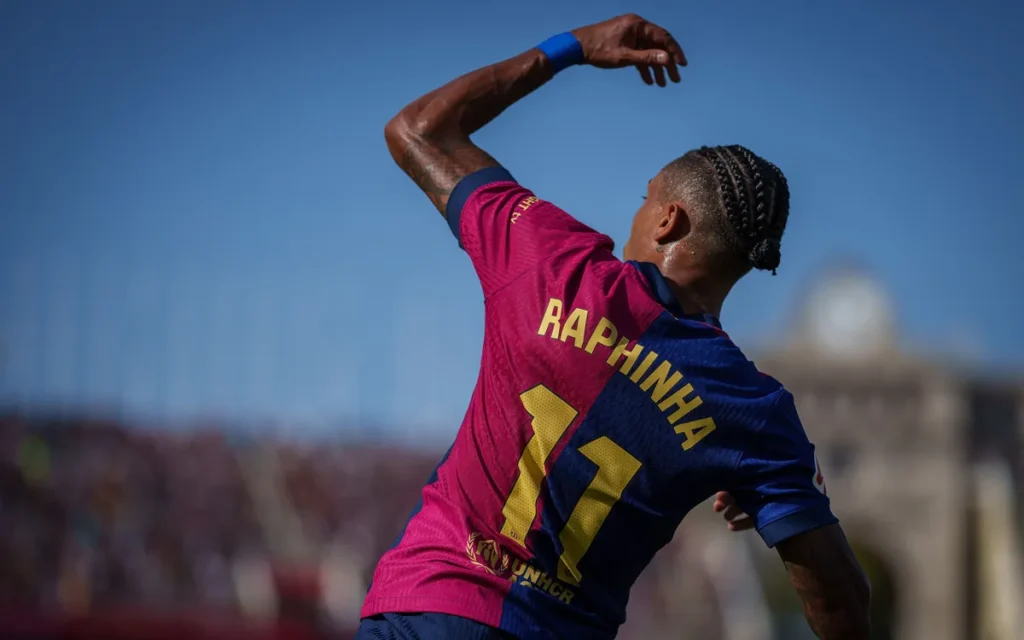 Barcelona player Raphinha punching the air with his left fist at the Camp Nou
