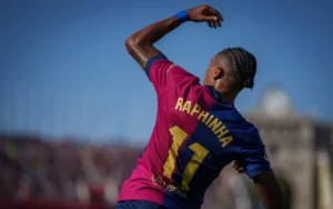 Barcelona player Raphinha punching the air with his left fist at the Camp Nou