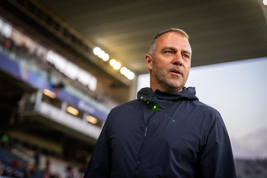 Barcelona coach Hansi Flick standing in a stadium at night