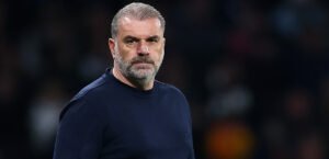 Tottenham Hotspur boss Ange Postecoglou standing against a dark background