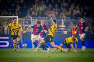 Barcelona player Lewandowski vying for the ball with Borussia Dortmund players