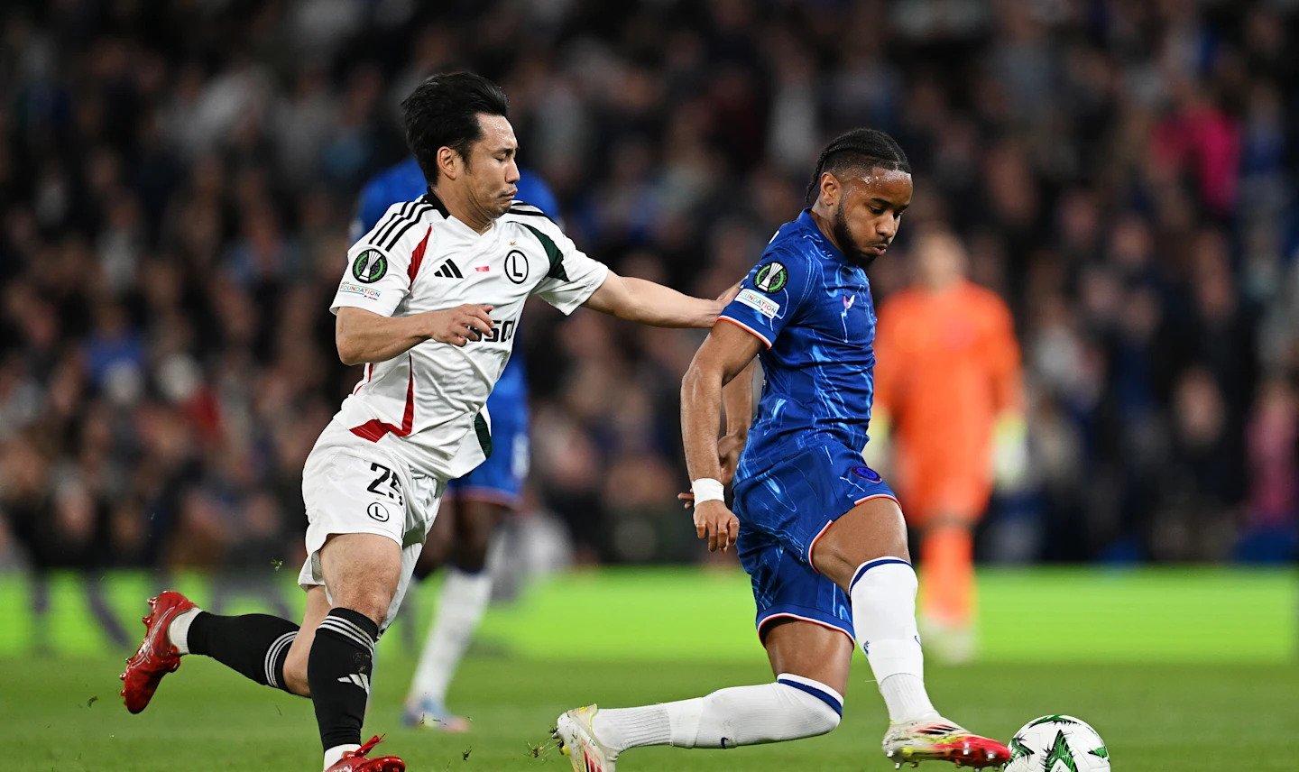 Chelsea player Christopher Nkunku vying for the ball with a Legia player