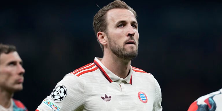 Bayer Munich forward Harry Kane standing in a stadium at nighttime