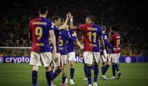 Barcelona player Robert Lewandowski walking with his teammates on a pitch