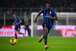 Inter Milan forward Marcus Thuram chasing the ball in a stadium during a football match