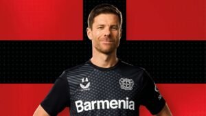 Bayer Leverkusen Manager Xabi Alonso stading with Leverkusen logo in the background