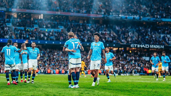 Manchester City midfielder Kevin De Bruyne higging his teammates after a goal at the Etihad