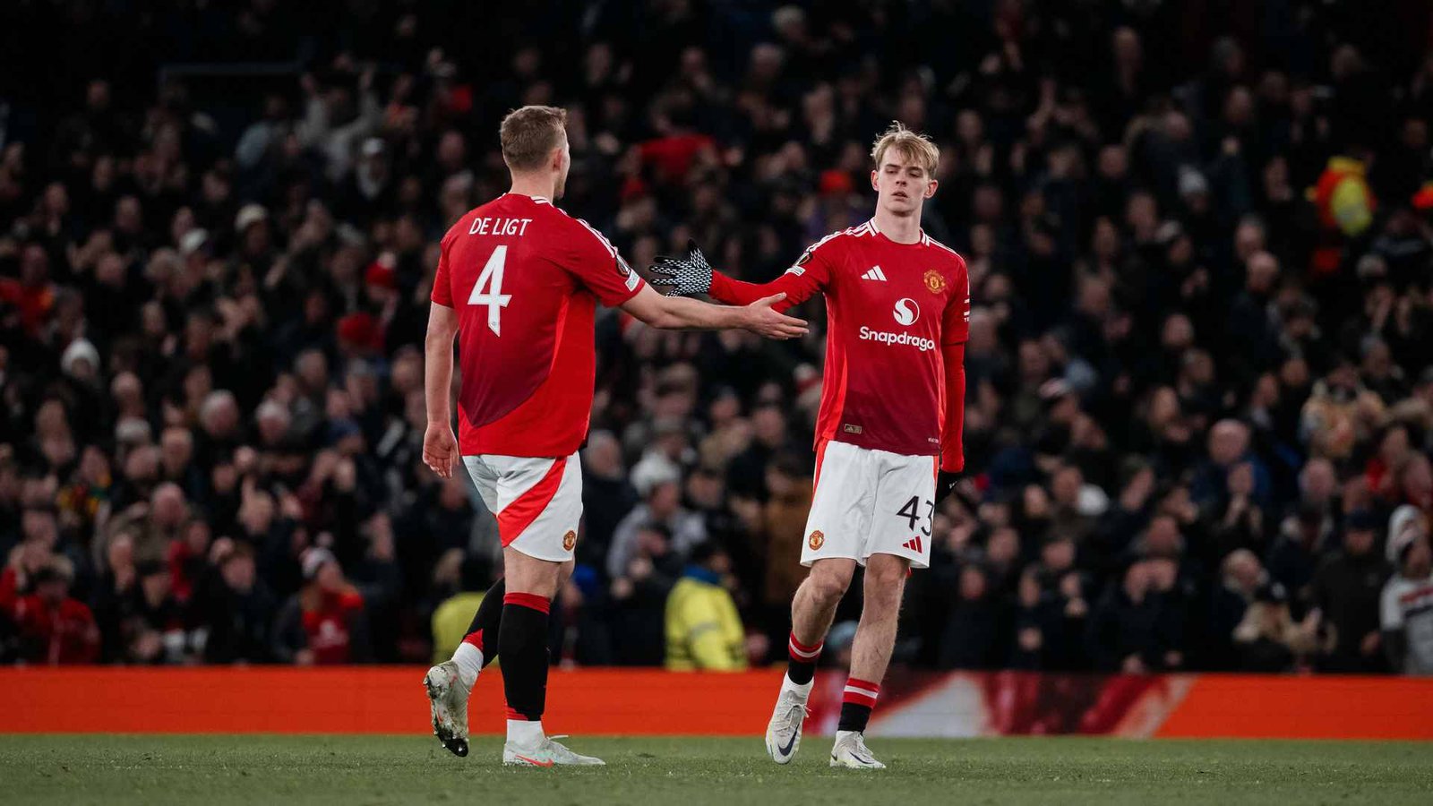 Manchester United defender Matthijs De Ligt clapping hands with Toby Collyer during a match