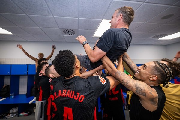 Barcelona players lifting manager Hansi Flick after title win