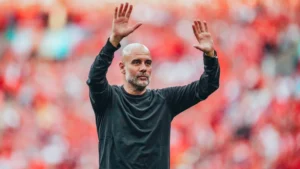 Manchester City manager Pep Guardiola raising his hands after a football match