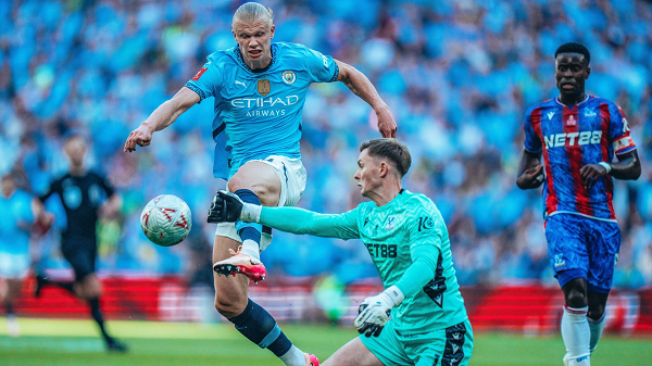 Dean Henderson slaps the ball away as Haaland tries to take it round him