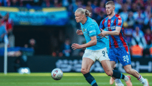 Erling Haaland fending off a challenge from Crystal Palace midfielder Adam Wharton