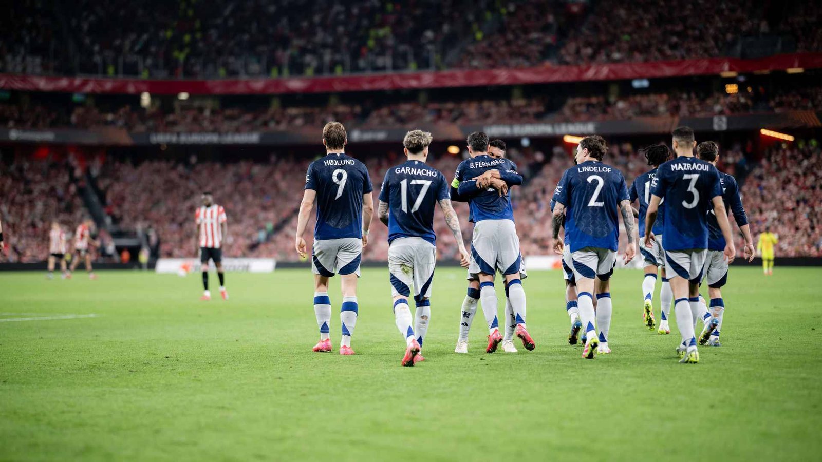 Manchester United players walking on the pitch after a football match