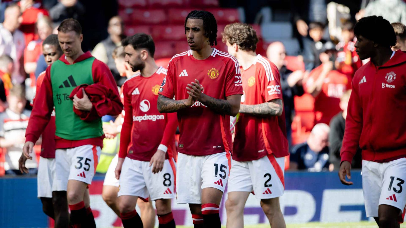 Manchester United players walking on the pitch after a match