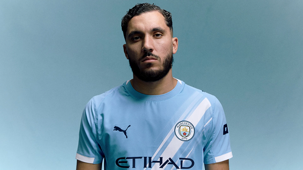 Rayan Cherki posing in a Manchester City shirt
