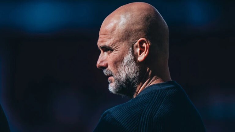 Pep Guardiola watching from the sideline during a Manchester City game in the Premier League