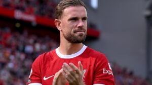 Jordan Henderson applauding fans during a Liverpool game at Anfield.