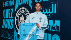 Tijjani Reijnders holding a Manchester City shirt after completing his £46.5m move from AC Milan