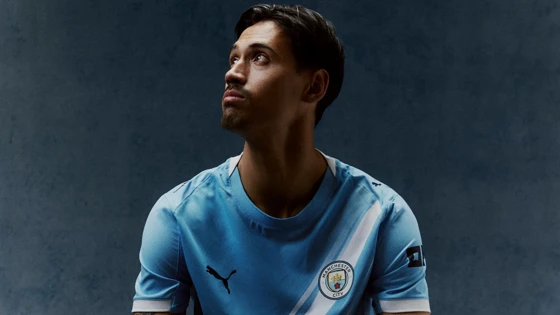 Tijjani Reijnders posing in a Manchester City shirt