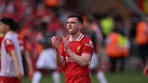Liverpool left-back Andy Robertson applauding fans after a match at Anfield