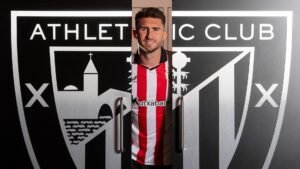 Aymeric Laporte posing in-between an Athletic Club badge built like a door