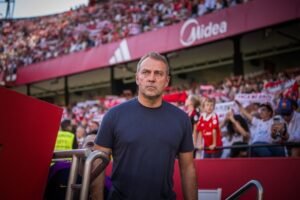 Barcelona manager Hansi Flick standing in front of the stands in Seville