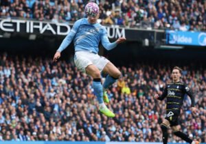 Erling Haaland jumps high to score a header for Manchester City against Everton
