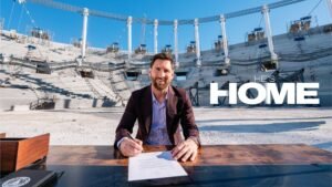 Lionel Messi sitting in stadium under construction and signing a document