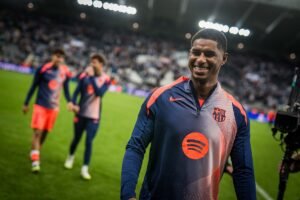 Marcus Rashford walking and smiling on the pitch in Barcelona colours