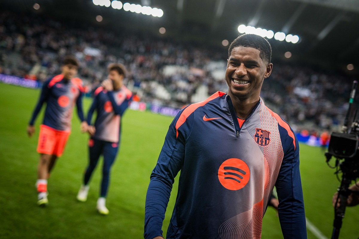Marcus Rashford walking and smiling on the pitch in Barcelona colours