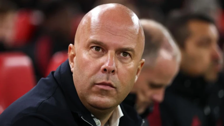 Arne Slot sitting in the dugout in a Liverpool game