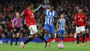 Brighton forward Danny Welbeck vying for the ball with Manchester United defender Leny Yoro