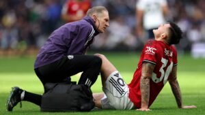 Manchester United's Benjamin Sesko sitting on the floor with medic attending him