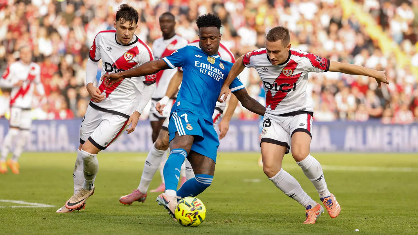 Real Madrid's Vinicius Junior being marked by Rayo Vallecano players