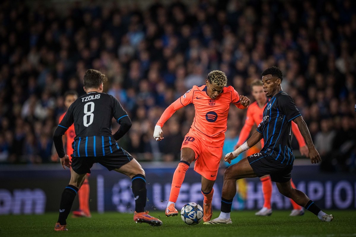 Barcelona winger Lamine Yamal dribbling through Club Brugge players