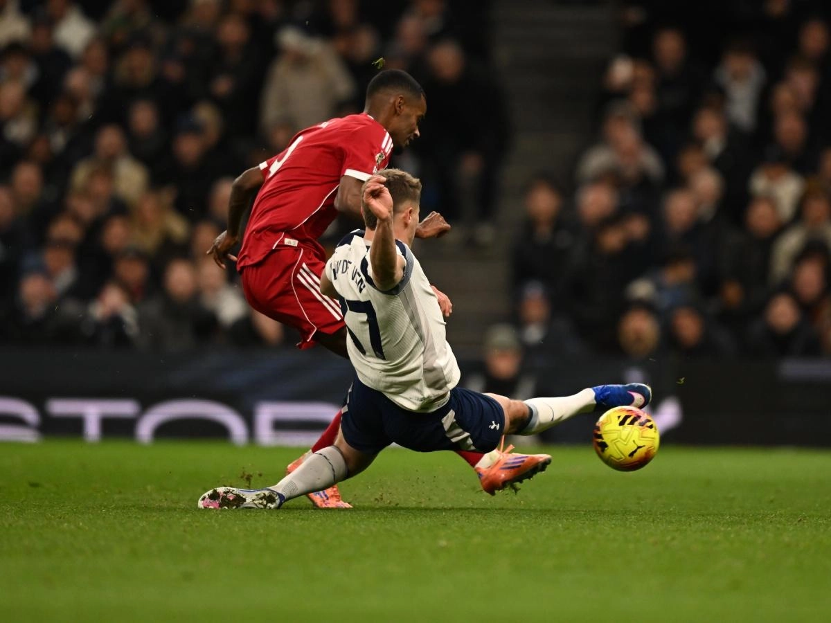 Alexander Isak scoring for Liverpool while Tottenham's Micky van de Ven tries to block