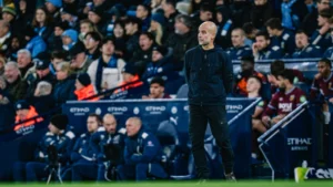 Pep Guardiola standing on the sidelines during a Manchester City game