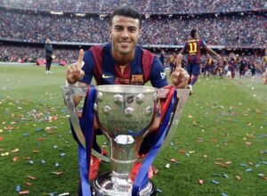 Barcelona midfielder Raphinha Alcantara posing with a trophy at Camp Nou