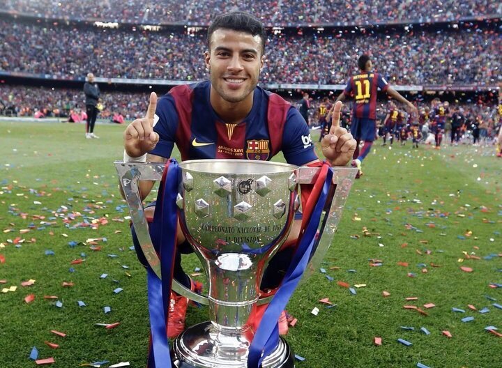 Barcelona midfielder Raphinha Alcantara posing with a trophy at Camp Nou