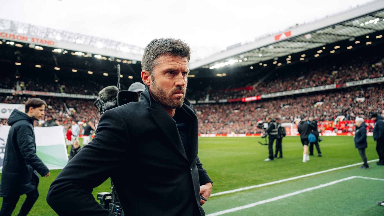 Manchester United coach Michael Carrick walking on Old Trafford pitch after derby against Manchester City