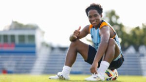 Endrick sitting on a ball at a training ground