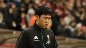 Wataru Endo walking in stadium in Liverpool jacket
