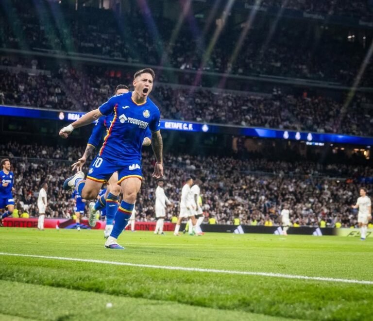 Getafe player Martin Satriano celebrating goal against Real Madrid at the Santiago Bernabeu while Madrid players walk dejectedly in the background