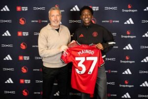 Kobbie Mainoo and Manchester United director of football Jason Wilcox both holding up a number 37 shirt after midfielder signs new contract