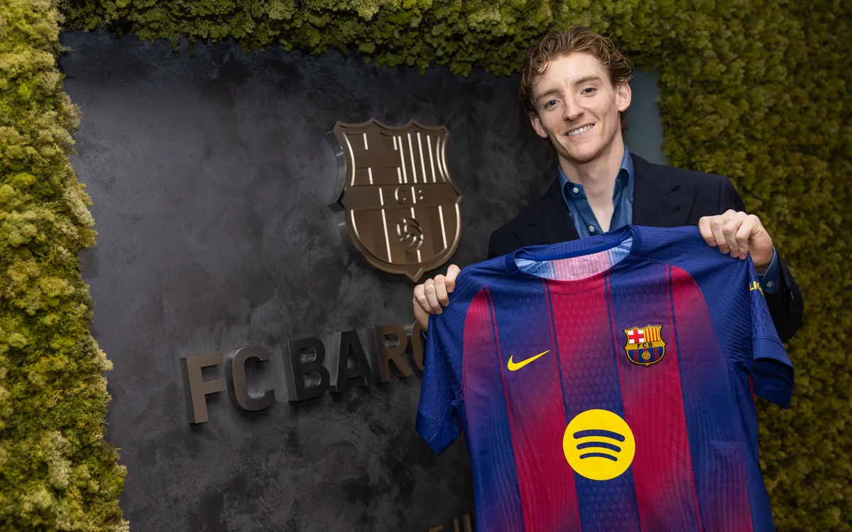 Anthony Gordon holding up a Barcelona shirt with 2031 written on it after signing for the club