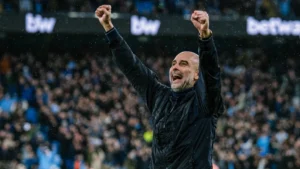 Manchester City coach Pep Guardiola celebrating a goal in the rain