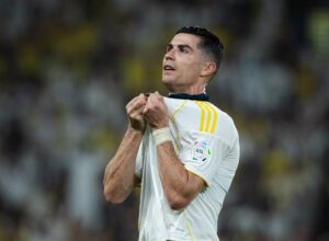 Cristiano Ronaldo celebrating by holding Al-Nassr badge