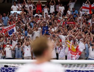 England fans celebrating at World Cup, with Harry Kane blurred in the foreground