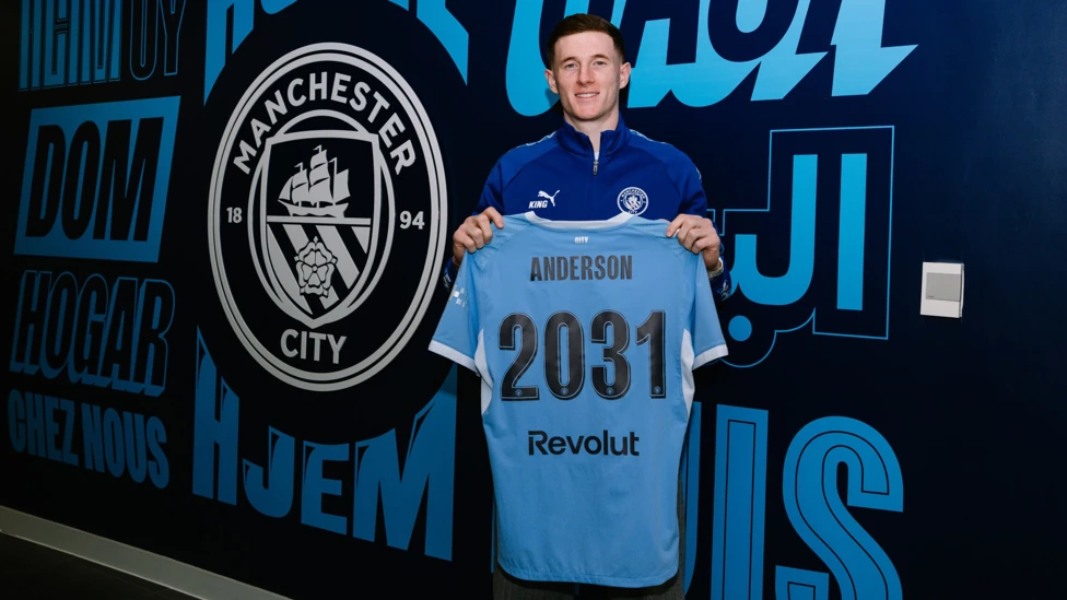 Elliot Anderson posing with a Manchester City shirt