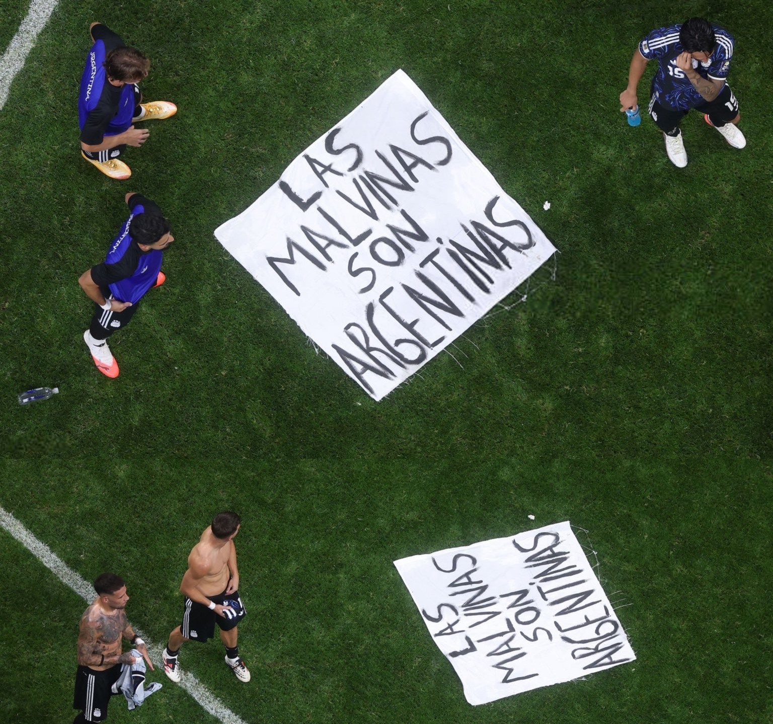 Argentina players standing around a banner on the pitch
